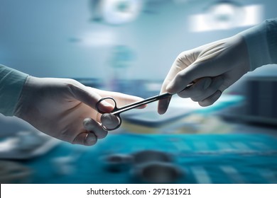 healthcare and medical concept , Close-up of surgeons hands holding surgical scissors and passing surgical equipment , motion blur background. - Shutterstock ID 297131921
