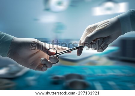 healthcare and medical concept , Close-up of surgeons hands holding surgical scissors and passing surgical equipment , motion blur background.