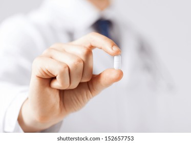 healthcare and medical concept - doctor with pill in hospital