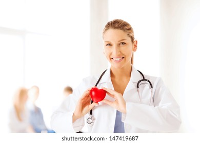 Healthcare And Medical Concept - Female Doctor With Heart