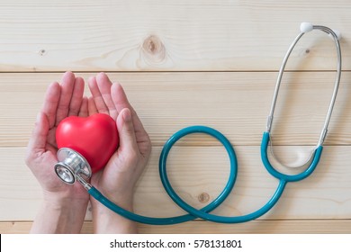 Healthcare medical insurance and World heart health day concept with red heart on woman's hands support
