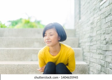 Healthcare Medical In Teenager Concept : First Period In Pre Teenager Girl At School, She Have A Stomachache Or Menstruation Pain Or Period Pain Sitting On A Stairs.