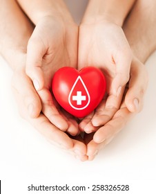 Healthcare, Medicine And Blood Donation Concept - Male And Female Hands Holding Red Heart With Donor Sign