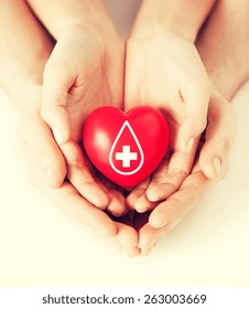 Healthcare, Medicine And Blood Donation Concept - Male And Female Hands Holding Red Heart With Donor Sign