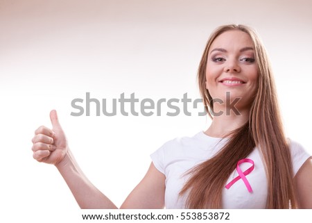 Healthcare, medicine and breast cancer awareness concept. Content young woman with pink cancer ribbon on chest making thumb up hand gesture