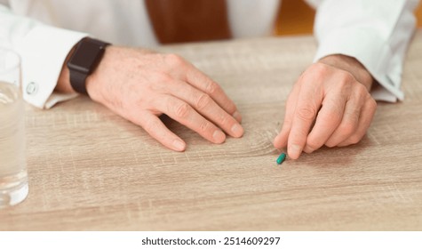 Healthcare and medicine. Close up of elderly man's hands with smartwatch taking pill from table. Cropped, selective focus, panorama - Powered by Shutterstock