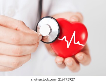 healthcare and medicine concept - close up of male doctor hands holding red heart with ecg line and stethoscope