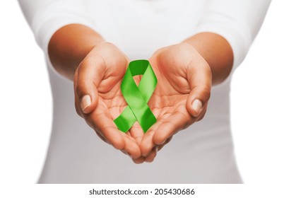 Healthcare And Medicine Concept - Female Hands Holding Green Organ Transplant Awareness Ribbon