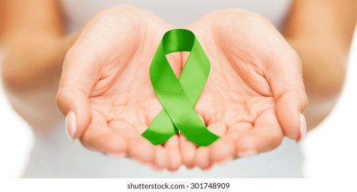 Healthcare And Medicine Concept - Female Hands Holding Green Organ Transplant Awareness Ribbon