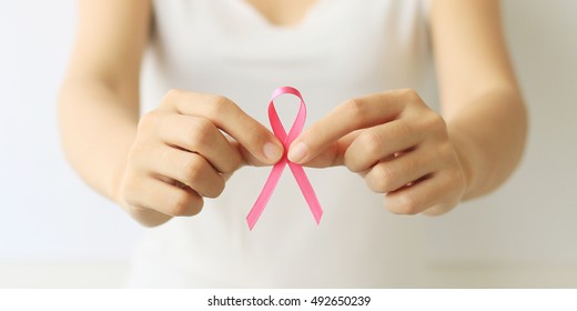 Gesundheitswesen und Medizin. Hand der Frau, die ein rosafarbenes Brustkrebsbewusstsein hält.