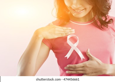 healthcare and medicine concept - woman with pink breast cancer awareness ribbon - Shutterstock ID 474456661