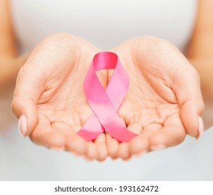 healthcare and medicine concept - womans hands holding pink breast cancer awareness ribbon - Shutterstock ID 193162472