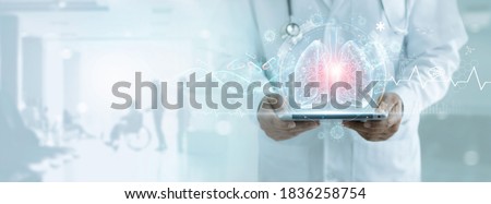 Healthcare and medicine, Covid-19, Doctor holding tablet and diagnose virtual Human Lungs with coronavirus spread inside on modern interface screen on hospital, Innovation and Medical technology.