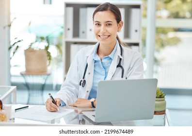 Healthcare, Medicine And A Doctor Writing On Insurance Document Or Patient File. Happy Woman Working In Medical Field, At Desk With Laptop Consulting Online And Filling In A Script At Hospital Office