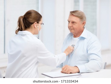 Healthcare, Medicine And Elderly Concept - Female Doctor Or Nurse With Old Man Listening To Heart Beat