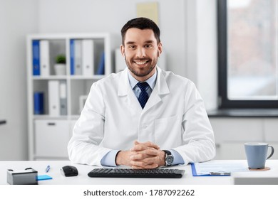 Healthcare, Medicine And People Concept - Happy Smiling Male Doctor With Earphones Having Video Conference At Hospital