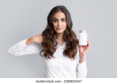 Healthcare and medicine. Portrait of attractive girl holding on bottle pills healthy product over gray background. Healthy hair care concept.