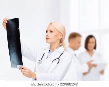 Healthcare, Medicine And Radiology Concept - Serious Female Doctor Looking At X-ray