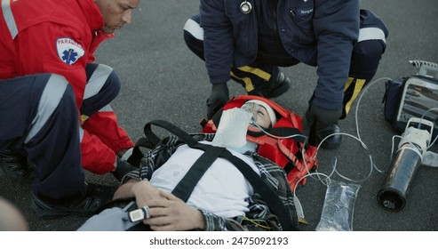 Healthcare, paramedic and help patient in street on scene for emergency, rescue and support. Emt team, people and oral oxygen for injured person on accident for medical service, care and first aid - Powered by Shutterstock