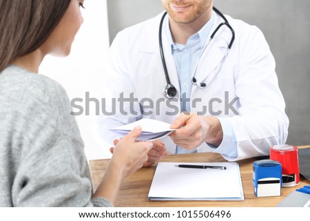 Healthcare. A patient in a doctor's office. The doctor enters recommendations and prescriptions.