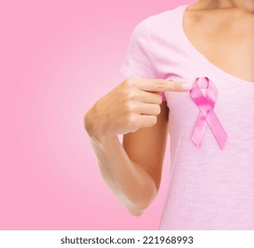 healthcare, people, charity and medicine concept - close up of woman in t-shirt with breast cancer awareness ribbon over pink background - Shutterstock ID 221968993