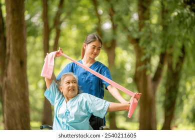 Healthcare or physical therapy nurse is helping elderly woman in performing a stretching or rehabilitation exercise with a resistance band caregiver individuals focused rehabilitation elderly concept. - Powered by Shutterstock