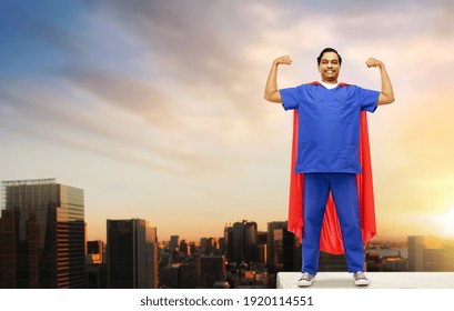 healthcare, power and medicine concept - happy smiling indian doctor or male nurse in blue uniform and red superhero cape with stethoscope showing biceps over sunrise in tokyo city background - Powered by Shutterstock