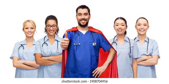 Healthcare, Profession And Medicine Concept - Doctor Or Male Nurse In Blue Uniform And Superhero Cape With Stethoscope Showing Thumbs Up Over International Team Of Medical Workers On White Background