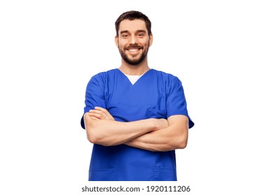 healthcare, profession and medicine concept - happy smiling doctor or male nurse in blue uniform with crossed arms over white background