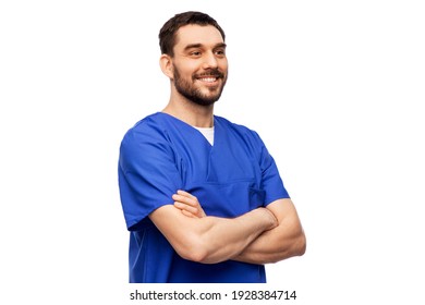 Healthcare, Profession And Medicine Concept - Happy Smiling Doctor Or Male Nurse In Blue Uniform With Crossed Arms Over White Background