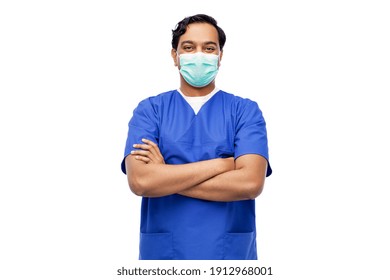 Healthcare, Profession And Medicine Concept - Indian Doctor Or Male Nurse In Blue Uniform And Face Protective Medical Mask For Protection From Virus Disease With Crossed Arms Over White Background