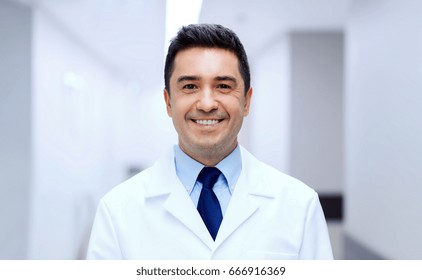 healthcare, profession, people and medicine concept - smiling male doctor in white coat at hospital