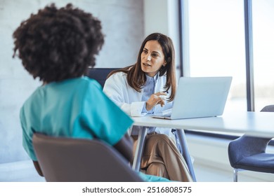 A healthcare professional having a discussion with a nurse in a contemporary office setting. The scene conveys collaboration, guidance, and communication in a medical environment. - Powered by Shutterstock