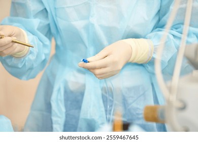 Healthcare professional in medical scrubs prepares equipment for surgical procedure in a sterile environment - Powered by Shutterstock