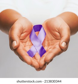 Healthcare And Social Problem Concept - Womans Hands Holding Purple Domestic Violence Awareness Ribbon