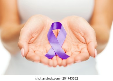 healthcare and social problems concept - womans hands holding purple domestic violence awareness ribbon - Shutterstock ID 204943552