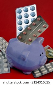 Healthcare Spending Concept With Medicine Blister Packs In Piggy Bank On Red Background