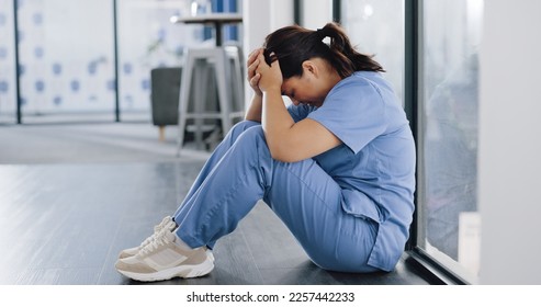 Healthcare, stress and sad nurse on floor with burnout, anxiety and headache working in emergency services. Medical care, mental health and health care worker with depression in hospital or clinic - Powered by Shutterstock