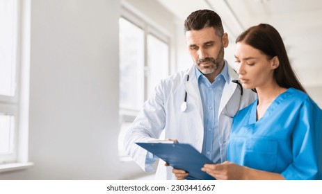 Healthcare teamwork. Male doctor and assistant reviewing patient's health history, having discussion in hospital office, copy space. Patient care coordination - Powered by Shutterstock