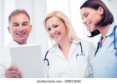 Healthcare And Technology Concept - Doctors Looking At Tablet Pc