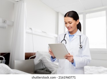 Healthcare, Technology And Medicine Concept - Smiling Female Doctor With Tablet Pc Computer Over Hospital Ward Background