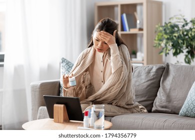 Healthcare, Technology And People Concept - Sick Asian Woman In Blanket With Medicine Having Video Call On Tablet Pc Computer At Home