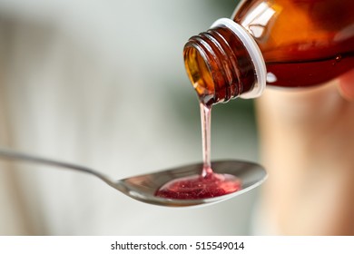 healthcare, treatment and medicine concept - bottle of medication or antipyretic syrup and spoon - Shutterstock ID 515549014