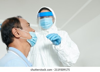 Healthcare Worker Collecting Swab Sample From Senior Patient For Covid 19 Test During Lockdown To Curb Spread Of Coronavirus