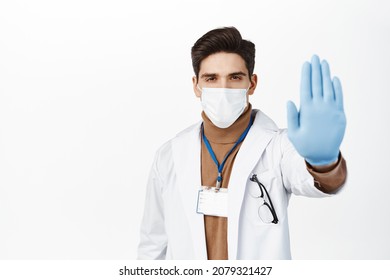 Healthcare Worker In Face Mask From Covid 19, Wearing Rubber Gloves, Showing Stop No Gesture, Taboo And Prohibition Sign, Standing Over White Background