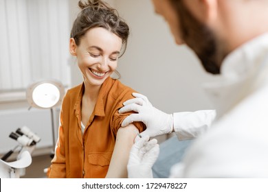 Healthcare Worker Gives An Injection Of A Vaccine Or Some Medication To A Young Girl In The Office. Vaccination Concept