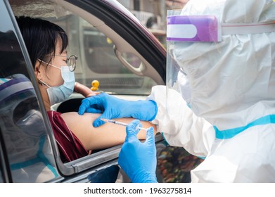 Healthcare Worker Giving Shot Of Covid-19 Vaccine To Patient's Shoulder In COVID-19 Drive-thru Detection Site.