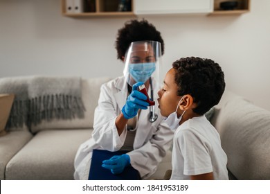 Healthcare Worker At Home Visit. Female Doctor Is Helping Little Boy To Use Asthma Pump