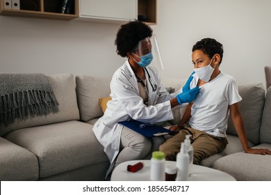 Healthcare Worker At Home Visit. Female Doctor Is Checking Symptoms Of Little Boy