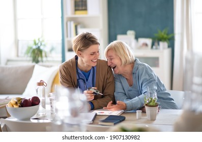 Healthcare Worker With Laughing Senior Woman Patient, Measuring Blood Glucose Indoors.